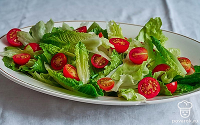 Нарвите листья салата романо и айсберг крупными кусочками, положите в салатник. Разрежьте помидоры черри пополам, добавьте к блюду.