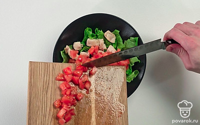 Переложите в салатницу нарезанный помидор.