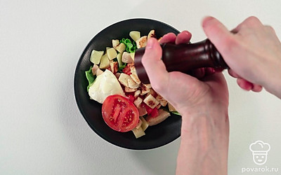 Украсьте салат половинкой помидора, добавьте соль и перец по вкусу.