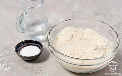 Посыпьте смесь солью. Влейте в нее воду и перемешайте ложкой.