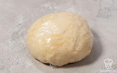 Замесите тесто до эластичности. Слепите из него шар. Накройте его пленкой и оставьте в тепле на 30 минут.
