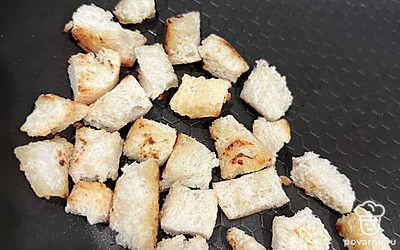 Хлеб нарежьте на маленькие кубики и обжарьте до румяности на сковороде.