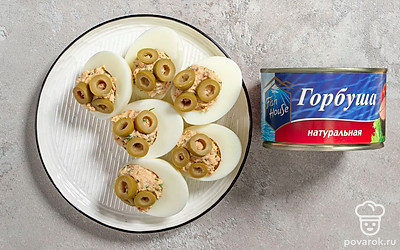 Украсьте яйца с рыбными консервами тонкими колечками оливок.