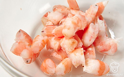 Остудите и нарежьте сваренные креветки на несколько частей. Положите их в миску.