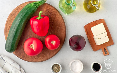 Помойте и почистите лук. Вымойте кабачок, помидоры и болгарский перец. Вырежьте у перца сердцевину с семенами, срежьте с кабачка грубую кожуру. Подготовьте разделочную доску, электрический гриль или сковороду-гриль, плоское сервировочное блюдо.