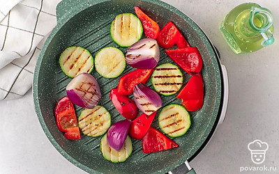 Разогрейте электрический гриль до температуры 220-230°C или сковороду-гриль на среднем огне. Смажьте сковороду или решетку гриля растительным маслом. Выложите на гриль или сковороду ломтики цукини, перца и лука. Обжарьте их с обеих сторон, периодически переворачивая, 4-5 минут до появления характерных темных полос.