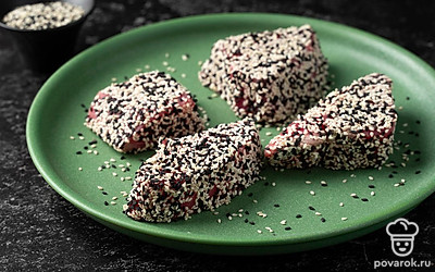 Насыпьте в тарелку кунжут. Обваляйте каждый кусочек филе тунца со всех сторон в кунжуте.