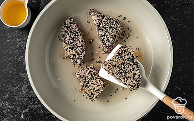 Разогрейте на сковороде растительное масло. Обжарьте на среднем огне тунца по 30 секунд с каждой стороны.