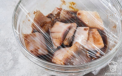 Положите в маринад сельдь, хорошо все перемешайте. Накройте рыбу пищевой пленкой и уберите в холодильник на 2 часа.