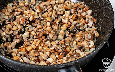 Мелко покрошите репчатый лук и шампиньоны. Разогрейте на сковороде растительное масло. Обжарьте грибы с луком на среднем огне в течение 10 минут, регулярно перемешивая, пока не выпарится жидкость.