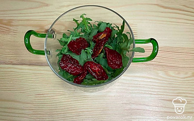 Выложите салат слоями. Сперва руколу, на нее — вяленые помидоры.