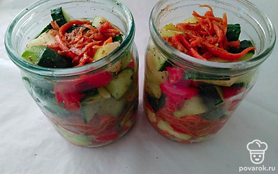 Морковь и овощи немного отожмите, распределите по банкам слоями, хорошо утрамбовывая, и залейте смешанным маринадом. Банки накройте крышками.