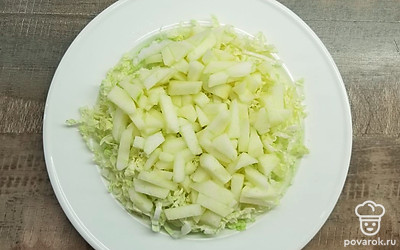 Нарежьте пекинскую капусту тонкой соломкой и выложите на блюдо. Яблоко очистите от кожуры и семян, нарежьте кубиками, выложите на капусту и сбрызните лимонным соком. Аккуратно перемешайте яблоки и капусту.