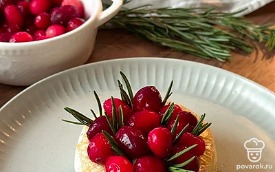 В горячий сыр вставьте маленькие пучки розмарина, выложите ягоды клюквы.