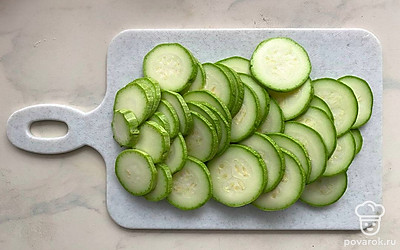 Кабачок нарежьте на кружки средней толщины и обжарьте на растительном масле с двух сторон. Огурцы порежьте колечками. Морковь по-корейски можете порубить на кусочки такого размера, чтобы удобно было ее есть в салате. Чеснок пропустите через пресс.