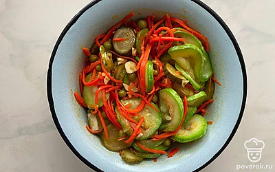 В глубокой миске соедините обжаренный кабачок, огурцы, морковь, консервированный горошек, чеснок и соль. Аккуратно перемешайте все ингредиенты.