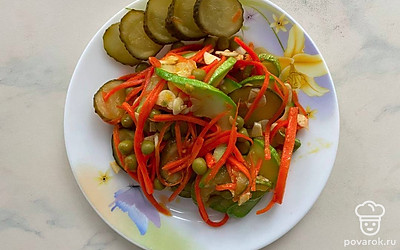 Готовый салат подавайте на стол в салатнике или выложите в порционные тарелочки, украсьте кружочками соленого огурца. Можете посыпать кунжутом и добавить веточки свежей зелени.