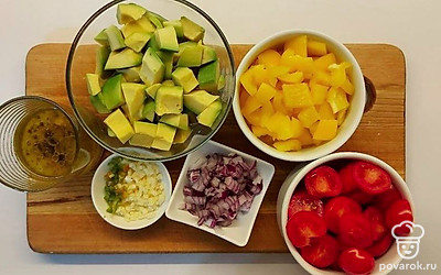 Разрежьте сладкий перец и вычистите семена. Нарежьте его кубиком среднего размера. Помидоры черри разрежьте пополам, лук мелким кубиком. Горький перец и чеснок максимально измельчите ножом. Авокадо почистите и нарежьте крупными кусочками.
