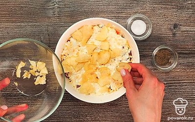 Приготовьте салат. На дно салатницы положите нарезанную курицу, ровно распределите. Слегка посолите и поперчите. Покройте тонким слоем майонеза. Выложите следующим слоем корейскую морковь. Смажьте ее майонезом. Следующим слоем выложите фасоль, покройте майонезом. Тертые яйца положите поверх фасоли и слегка смажьте майонезом. Распределите по поверхности салата нарубленные чипсы.