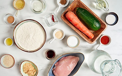 Разморозьте, помойте и промокните бумажным полотенцем куриное филе. Помойте и почистите кабачок, чеснок и морковь. Просейте муку. Подготовьте пароварку. Перед запеканием разогрейте духовку до 180°C. 