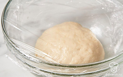 Переложите тесто на рабочую поверхность и хорошенько вымесите его руками в течение 10 минут. Положите тесто в миску, накройте пищевой пленкой и оставьте в теплом месте еще на 40 минут.