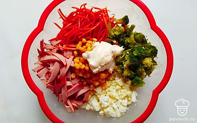 Подготовленные яйца порежьте кубиками среднего размера. Ветчину порежьте тонкими длинными брусочками. Слейте маринад с консервированной кукурузы. Соедините все подготовленные ингредиенты, добавьте корейскую морковь и аккуратно перемешайте. Попробуйте и при необходимости доведите до вкуса, добавив соль. Заправьте салат майонезом и снова перемешайте.