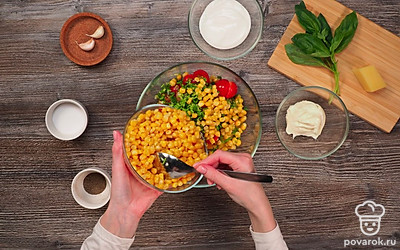 Подготовьте овощи для салата и смешайте их. Для этого очистите болгарский перец от семян и нарежьте его крупными кубиками. Разрежьте помидоры пополам. Порубите мелко зелёный лук. Смешайте перец, помидоры, лук и добавьте к ним кукурузу.