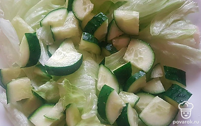 Огурец помойте и нарежьте небольшими кусочками. Выложите поверх салата. 