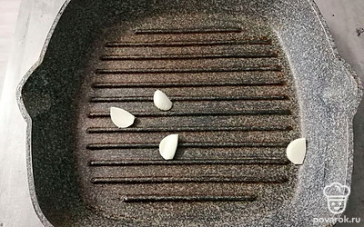 В сковороду выложите очищенные зубчики чеснока. 