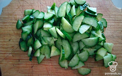 Огурцы тонко нарезать. Переложить в салатницу к капусте.