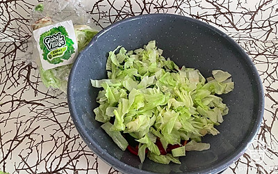 Нарежьте ножом или разорвите руками салат айсберг, добавьте к овощам.