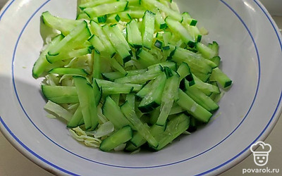 Сверху выложите нашинкованный огурец. Полейте растительным маслом.