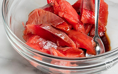 Выложите рыбу в миску. Влейте к ней соевый соус и хорошо перемешайте.