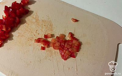 Мелко нарежьте помидор. 
