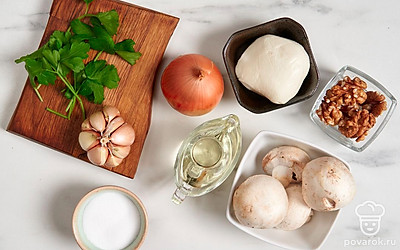 Вымойте и обсушите шампиньоны бумажными полотенцами. При необходимости срежьте темные пятна и почерневшую часть ножки. Помойте и очистите лук и чеснок. Ополосните петрушку. Подготовьте кастрюлю, сковороду, терку и форму для запекания.