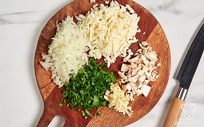 Мелко порубите ножки шампиньонов. Измельчите лук, чеснок и веточки петрушки. Натрите моцареллу.