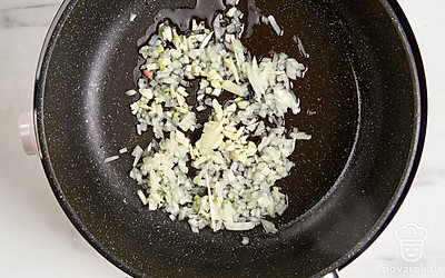 Влейте в сковороду масло и разогрейте его на умеренном огне. Выложите лук и чеснок. Обжаривайте овощи примерно 3-4 минут, помешивая.
