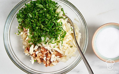 Переложите обжаренные овощи в миску, охладите. Добавьте к ним орехи, тертый сыр, зелень и специи. Хорошо перемешайте.