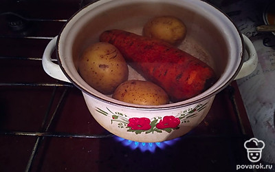 Ставим варить три картошки в мундире и одну морковь на 25 минут. Затем сливаем воду, заливаем их холодной водой. 